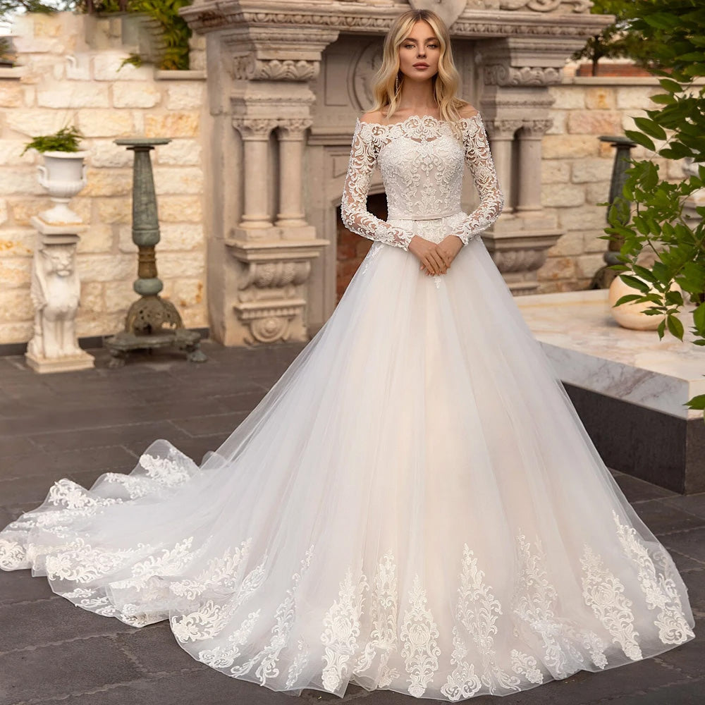 A model in a stunning off-the-shoulder lace bridal gown with long sleeves and an A-line silhouette, p