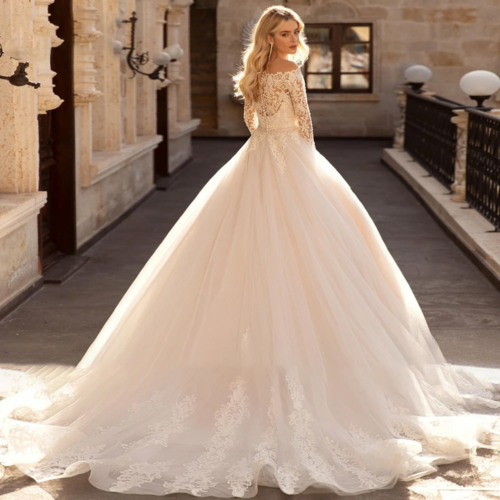 Back view of a bride walking down a stone terrace in a vintage A-line bridal gown, showcasing the elegant lace detail, long sleeves, and sweeping skirt.