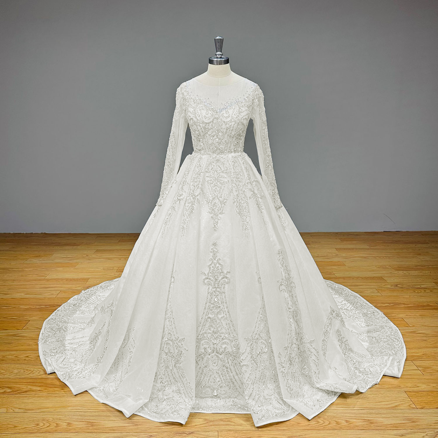 Studio product display of a magnificent sparkly ball gown wedding dress with sheer long sleeves and exquisite all-over sequin beading on a mannequin.