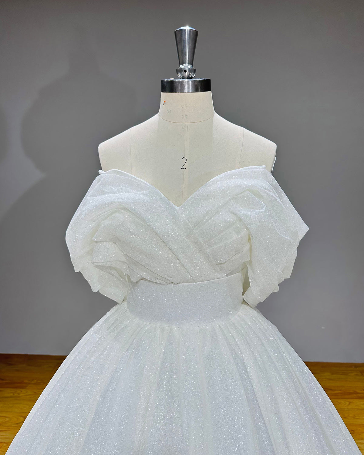 Medium front shot of the vintage-inspired V-neck wedding gown bodice featuring structured overlapping fabric folds and a clean waistband.