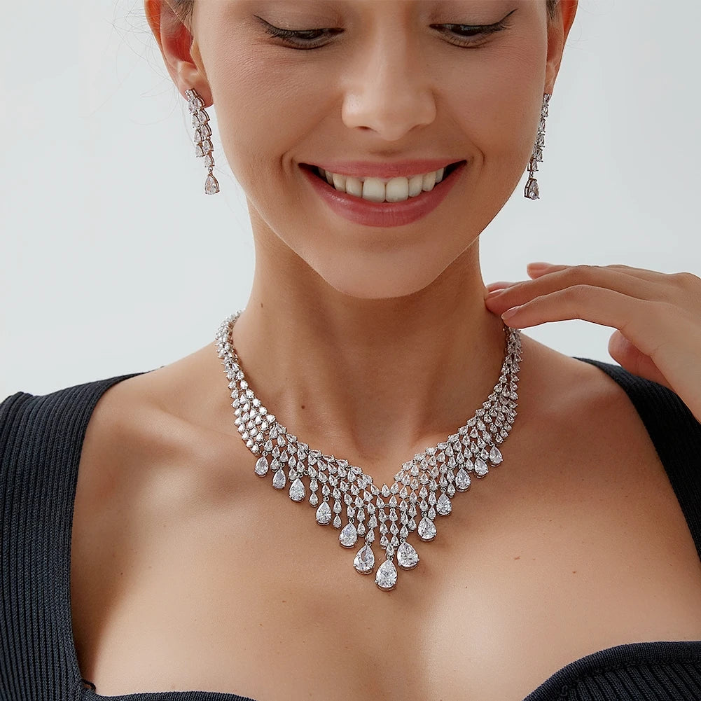 Close-up of a smiling model wearing a shiny AAA cubic zirconia bridal necklace and matching teardrop dangle earrings.