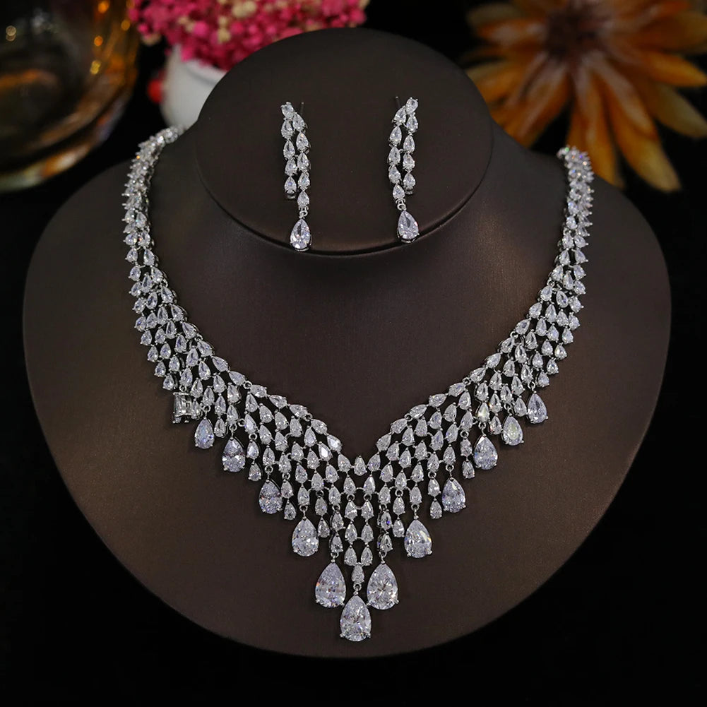 Front profile view of a luxury cubic zirconia wedding jewelry set with a cascading teardrop necklace on a dark bust.