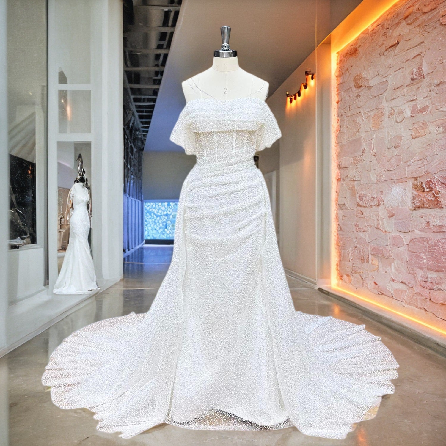 Shimmering off-the-shoulder mermaid wedding dress with all-over crystal beading and a matching detachable train displayed on a boutique dress form.