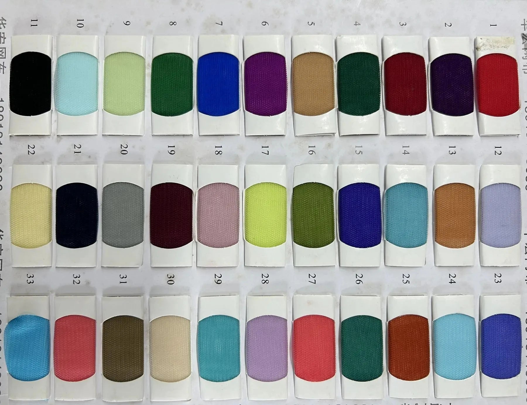 Numbered textile swatch catalog showing a wide range of custom colorful mesh and tulle fabric options for tailored party dresses.
