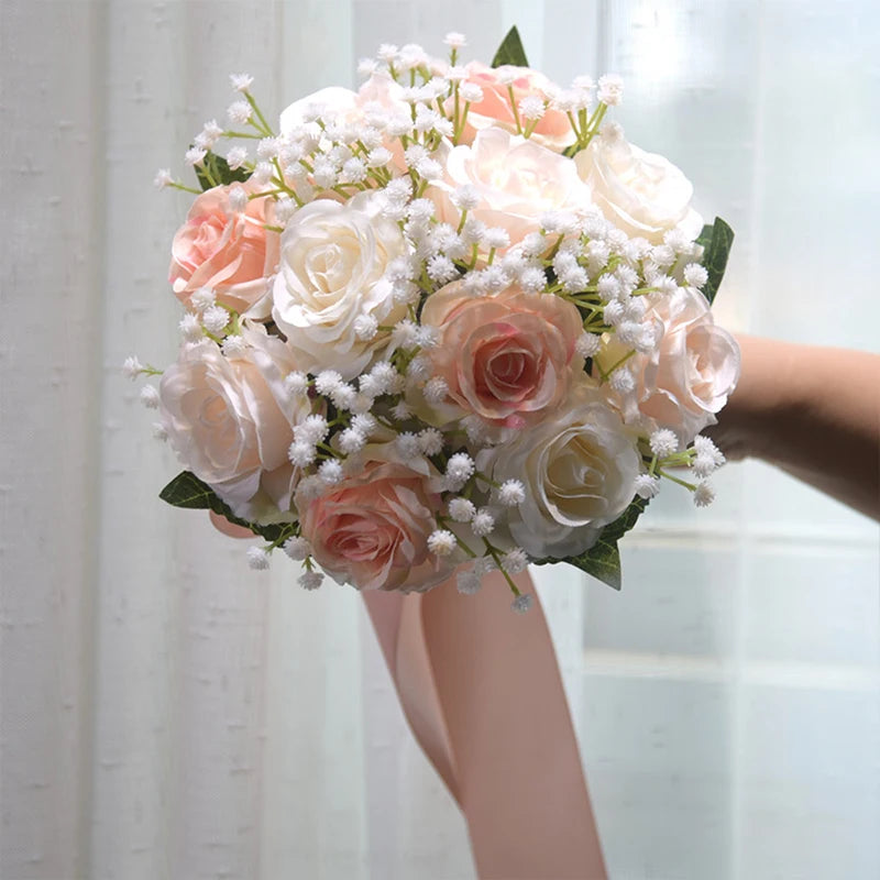 Faux silk wedding bouquet composed of light blush pink and ivory cream roses tied with a long satin ribbon.