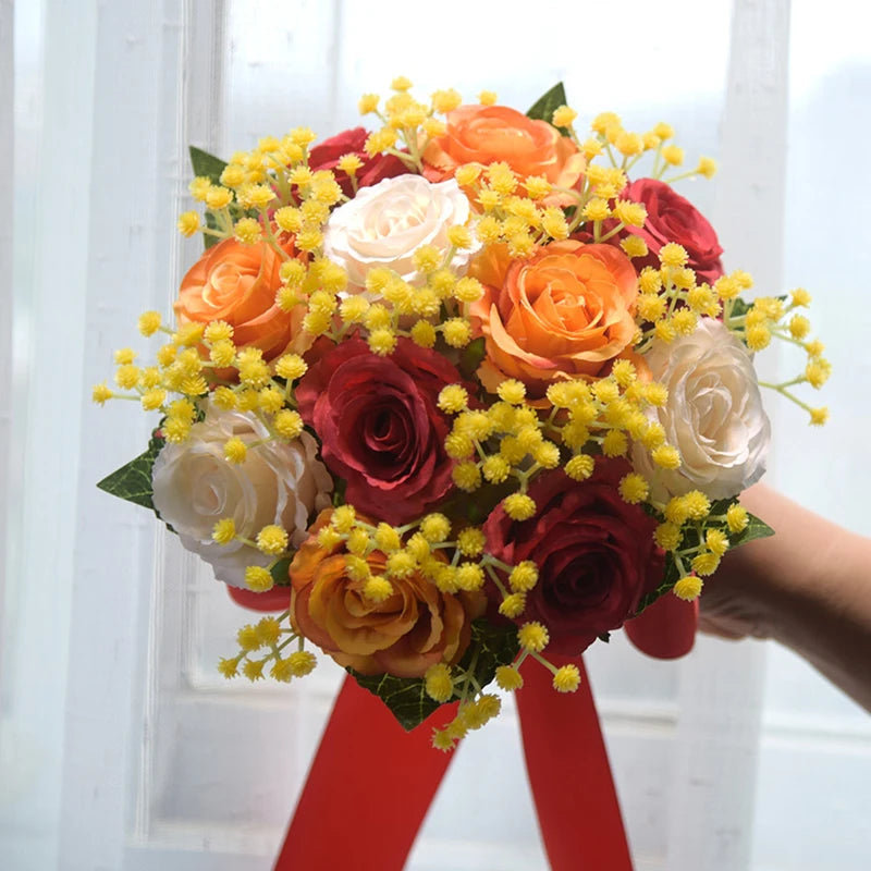 Autumn-themed bridal party bouquet crafted with dark red, orange, and white silk roses accented by bright yellow mimosa sprigs.
