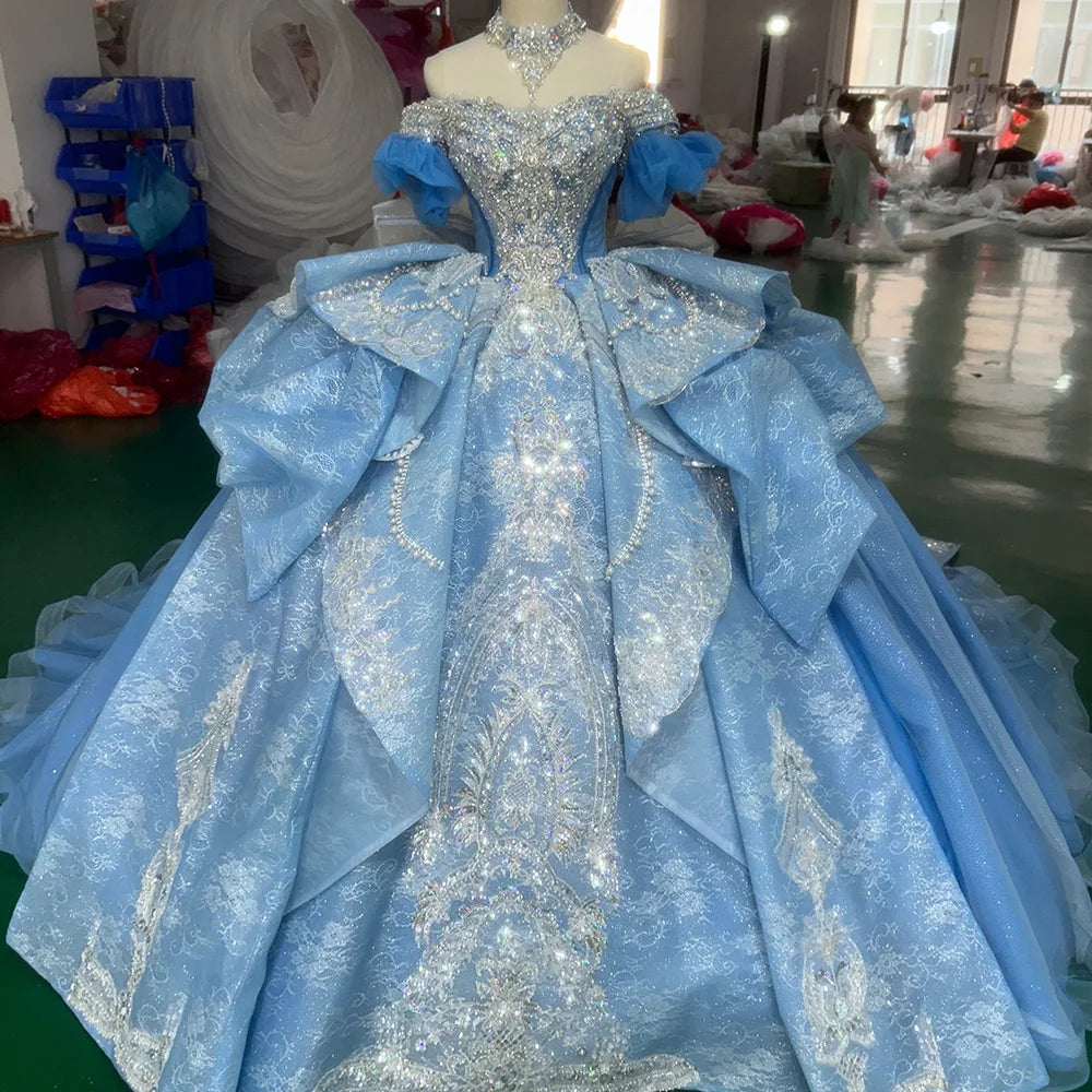 Front view of a sparkling ice blue princess bridal gown on a mannequin, highlighting the dense silver crystal beadwork and shimmering glitter tulle fabric.