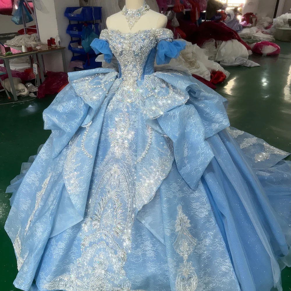 Three-quarter side angle of a dramatic sky blue fairytale wedding dress on a mannequin, detailing the immense volume of the layered skirt and reflective sequin patterns.