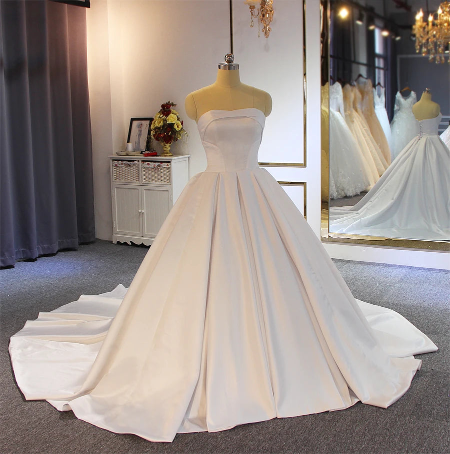 Front-angled view of a timeless satin ball gown bridal dress, showcasing the clean lines and sophisticated silhouette perfect for an elegant marriage ceremony.
