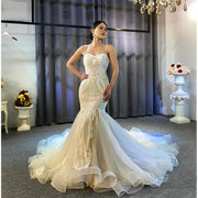 Front view of a model wearing a slim lace wedding dress featuring an elegant deep V-neckline, long sheer lace sleeves, and an intricately beaded bodice.