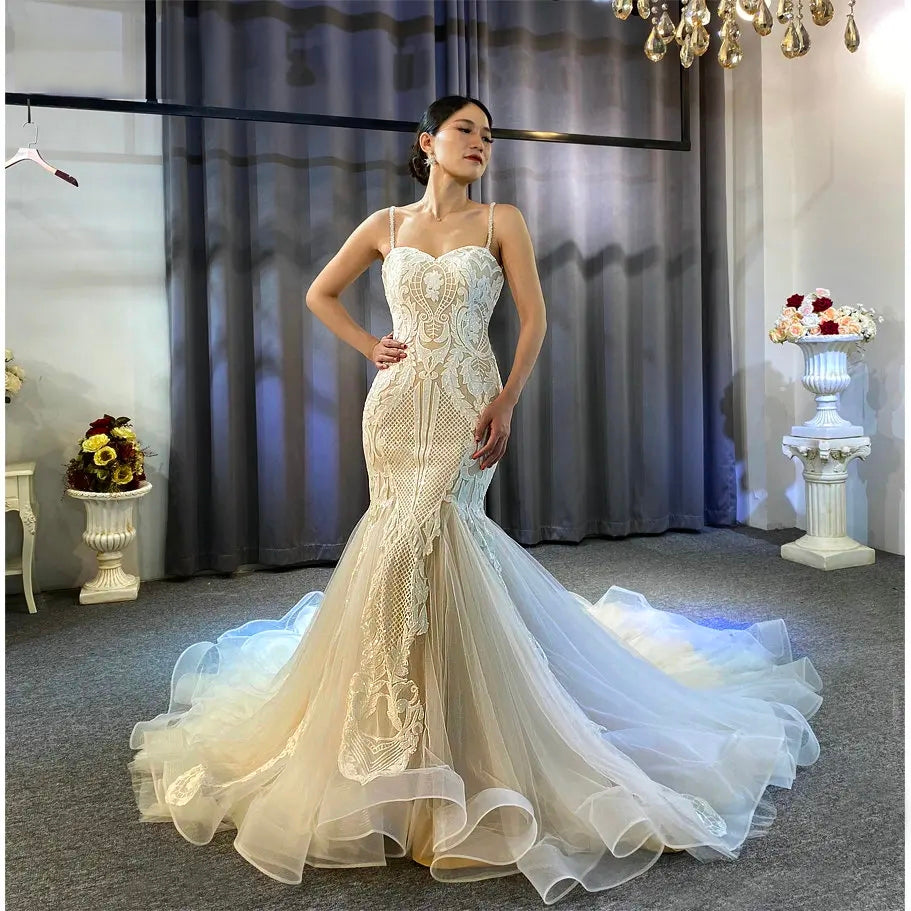 Front view of a model wearing a slim lace wedding dress featuring an elegant deep V-neckline, long sheer lace sleeves, and an intricately beaded bodice.