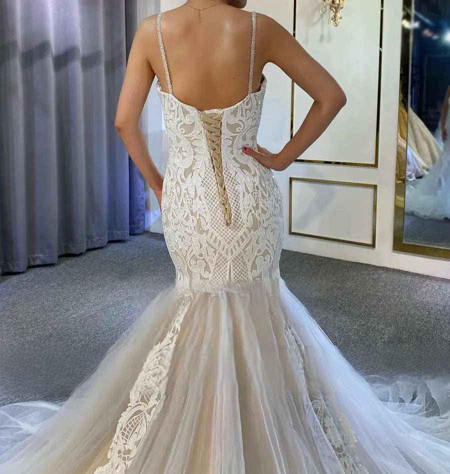 Close-up detail of the V-neckline and beaded lace bodice of an elegant slim wedding dress, focusing on the high-quality floral appliqués and craftsmanship.