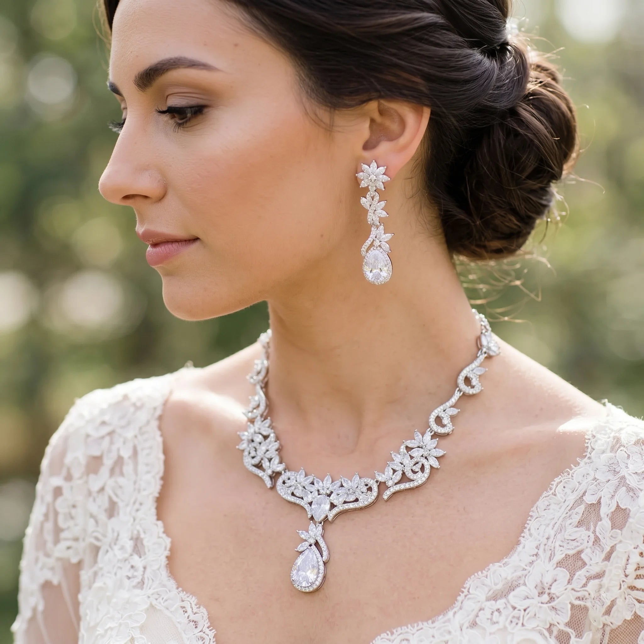 Side profile of a bride wearing a sparkly zircon crystal bridal necklace and matching flower dropdown earrings.