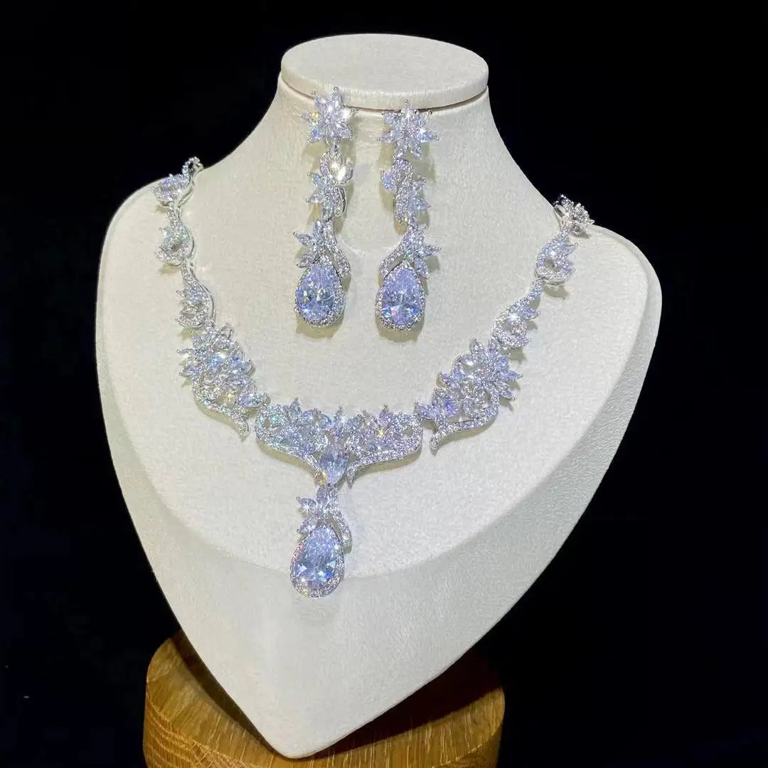 Sparkling silver zircon crystal bridal necklace set with a prominent teardrop pendant on a jewelry display bust.