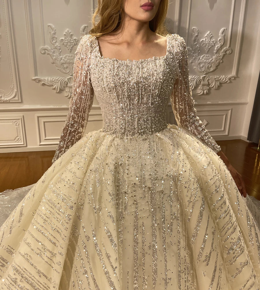 Close-up detail of a square neckline wedding dress bodice showcasing dense silver hand-beaded crystal work and intricate sequin craftsmanship.