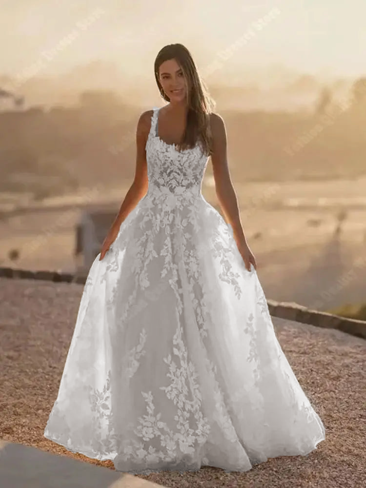 A front view of a sleeveless square-neck A-line bridal gown featuring a delicate, shining tulle finish.