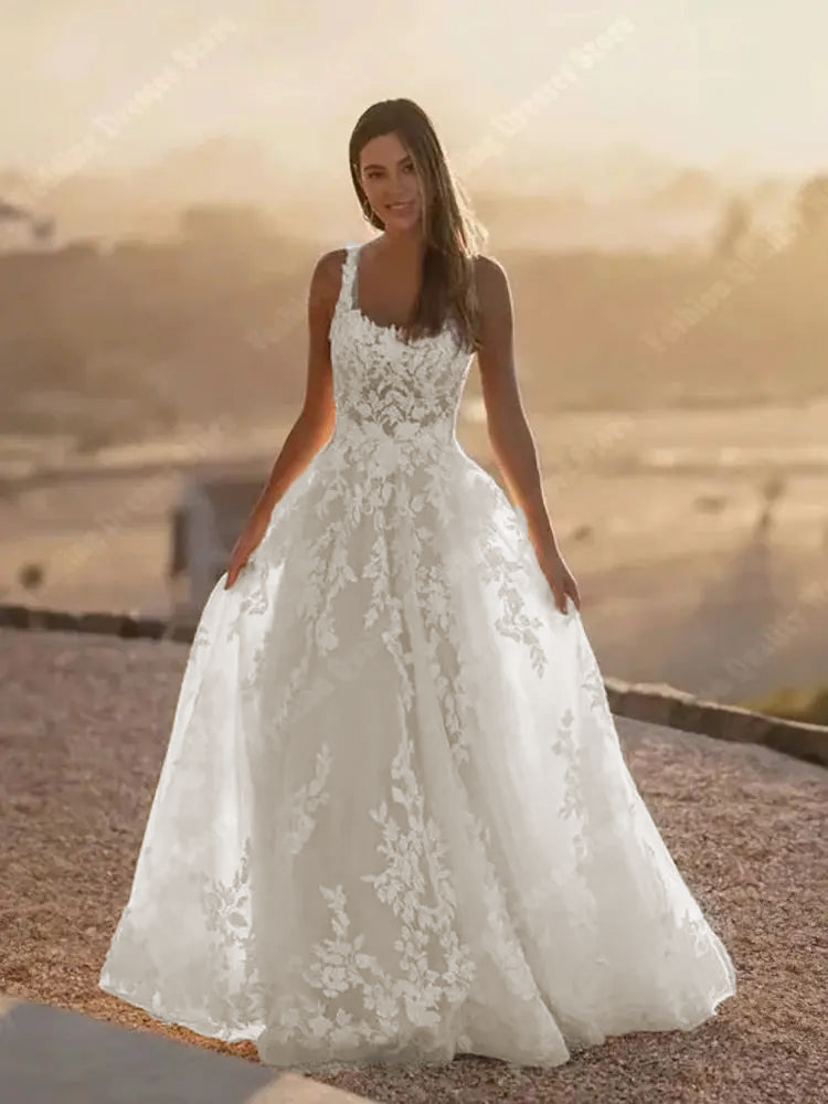 An elegant, sleeveless A-line wedding dress with a square neck and a shining tulle surface, ideal for a romantic bridal look.
