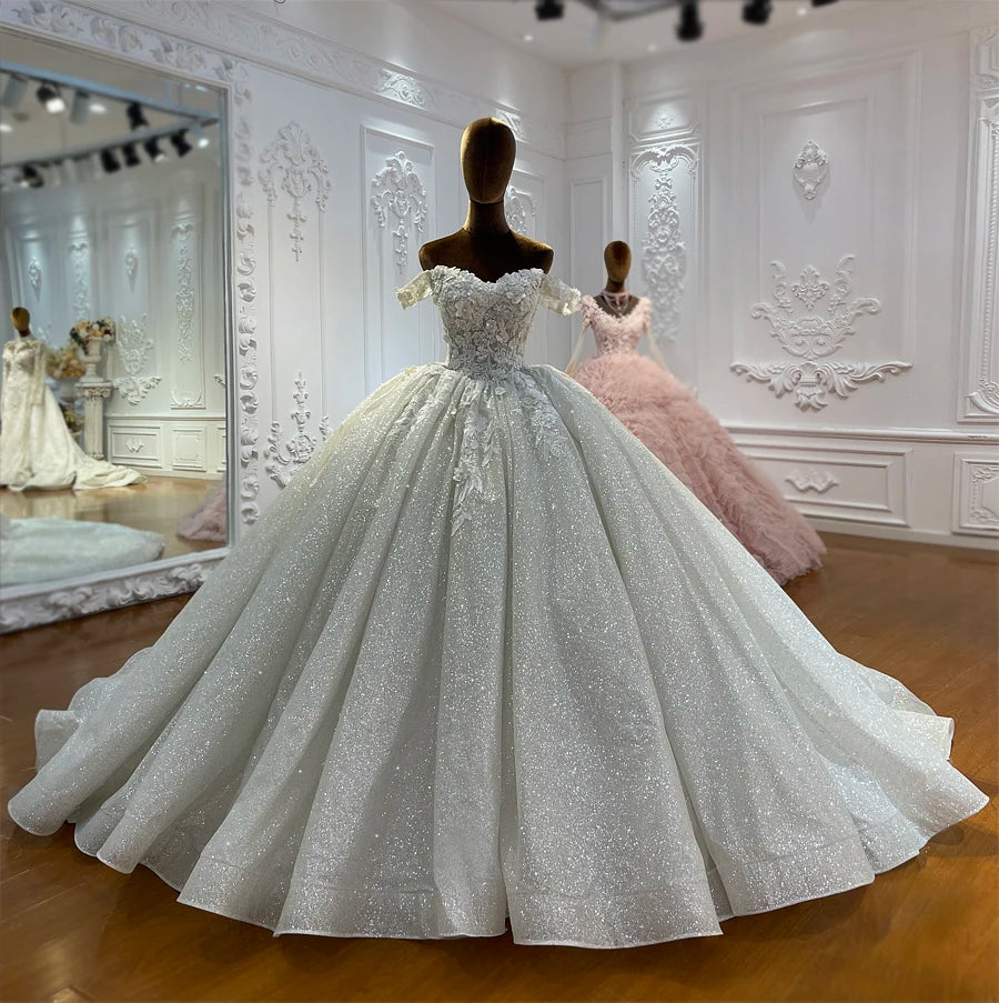 Detailed front view of a shimmering silver sequin bridal gown featuring a sweetheart neckline and off-shoulder straps.