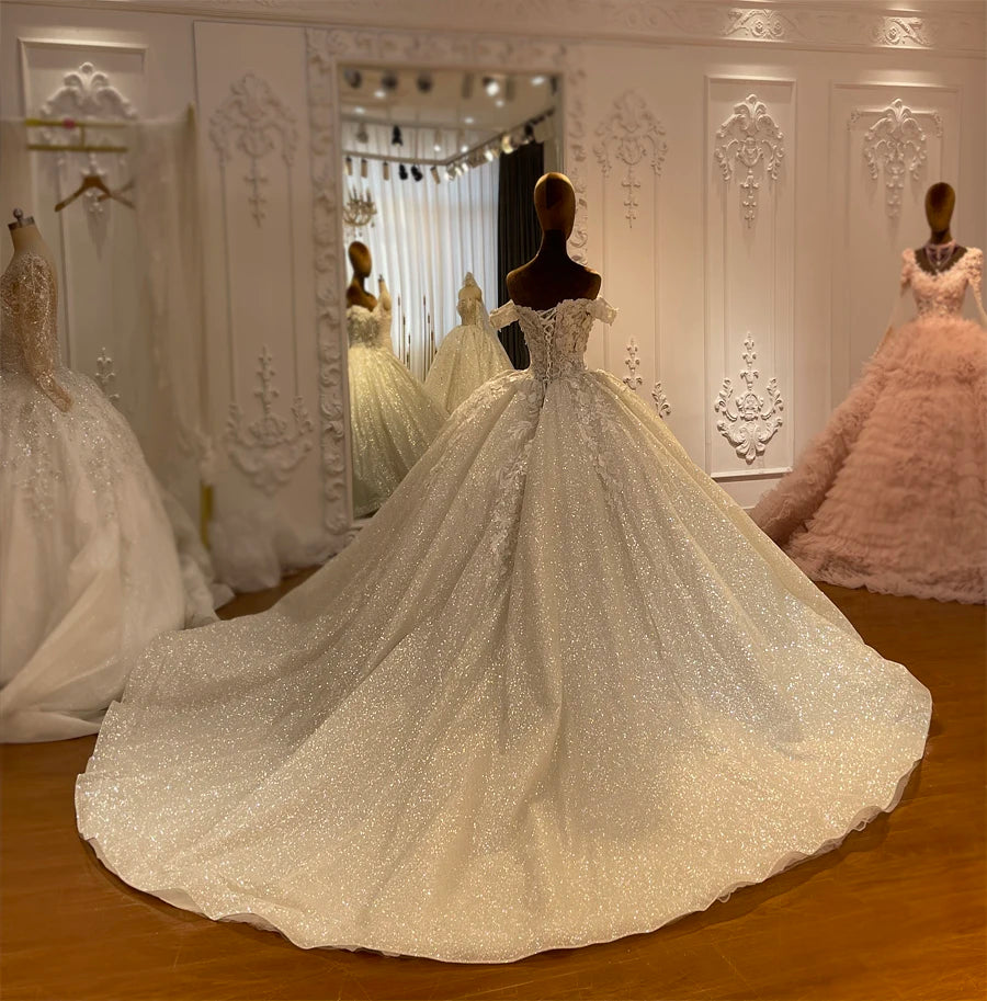 Angled back view of a glitter tulle wedding gown highlighting the full extension of its shimmering 100cm train.
