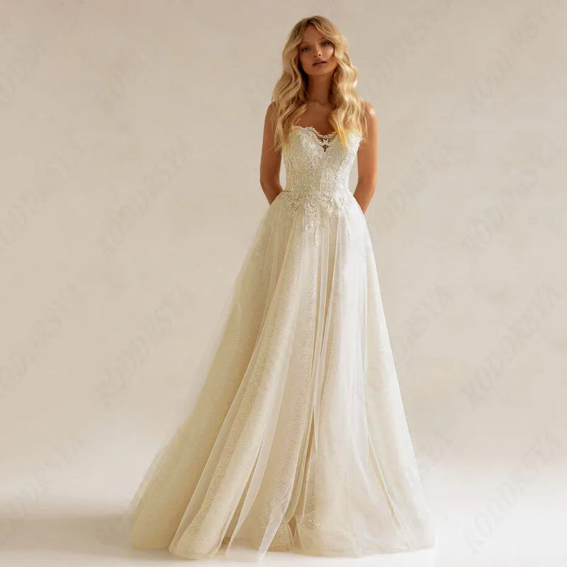 Rear view of an A-line wedding dress with a long train, showcasing intricate lace appliques and illusion detailing.