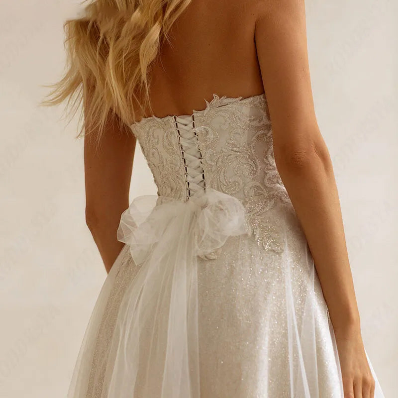 A back view of a bride in a full-sleeve A-line wedding gown, emphasizing the intricate lace-detailed long train.