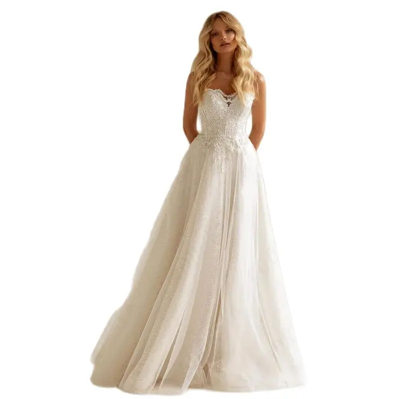 Side view of an A-line bridal gown with a long train, highlighting the lace embroidery on the full sleeves.