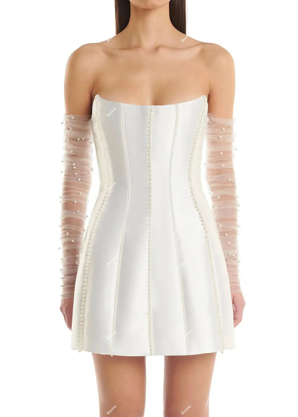 Close-up front view of a white strapless mini bridal party dress with vertical boning details, pearl accents, and sheer mesh sleeves.