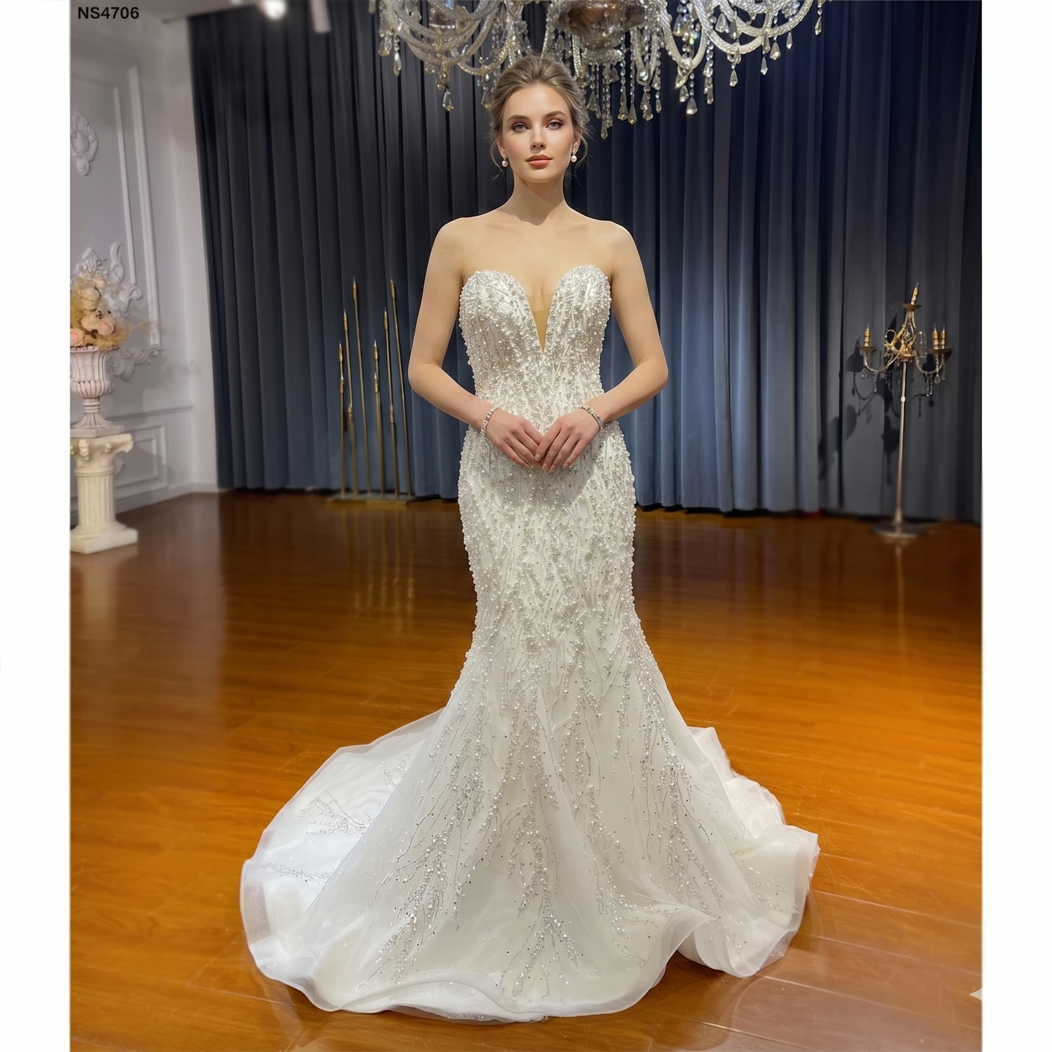 Full-length view of a bride wearing a timeless strapless slim mermaid wedding dress with an intricate pearl and crystal-beaded bodice and a sweetheart neckline.