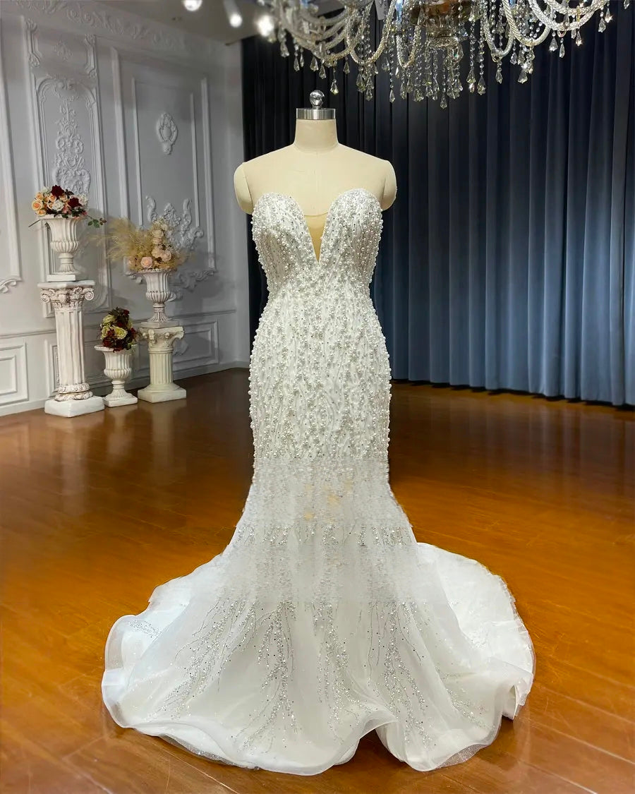 Direct front view of the beaded strapless mermaid bridal gown on a mannequin, highlighting the symmetrical pearl embroidery and the dramatic flared hem.