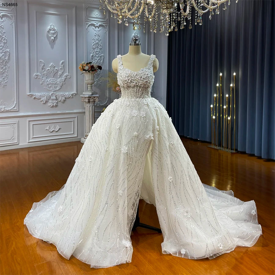 Mannequin display of a summer-style strappy wedding dress showcasing a high front slit and a flowing A-line silhouette.