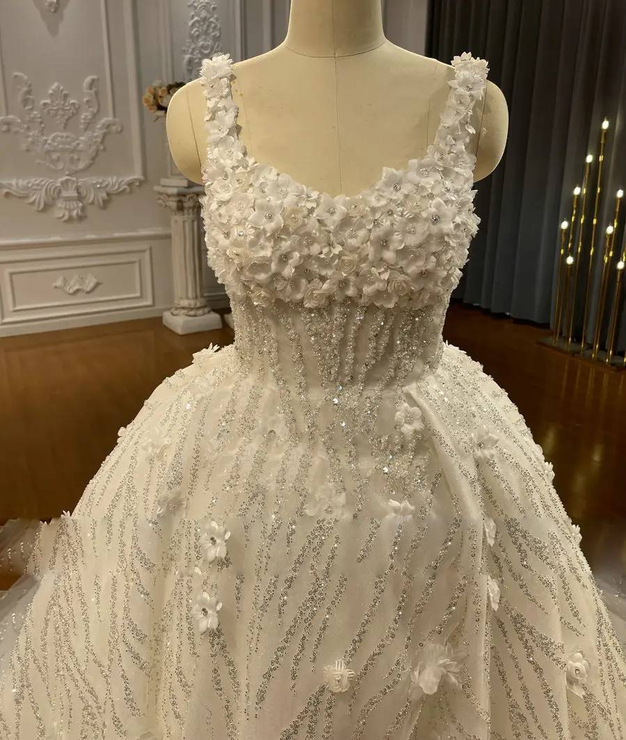 Close-up detail of a bridal bodice featuring scoop neckline, intricate floral embroidery, and shimmering sequin textures.