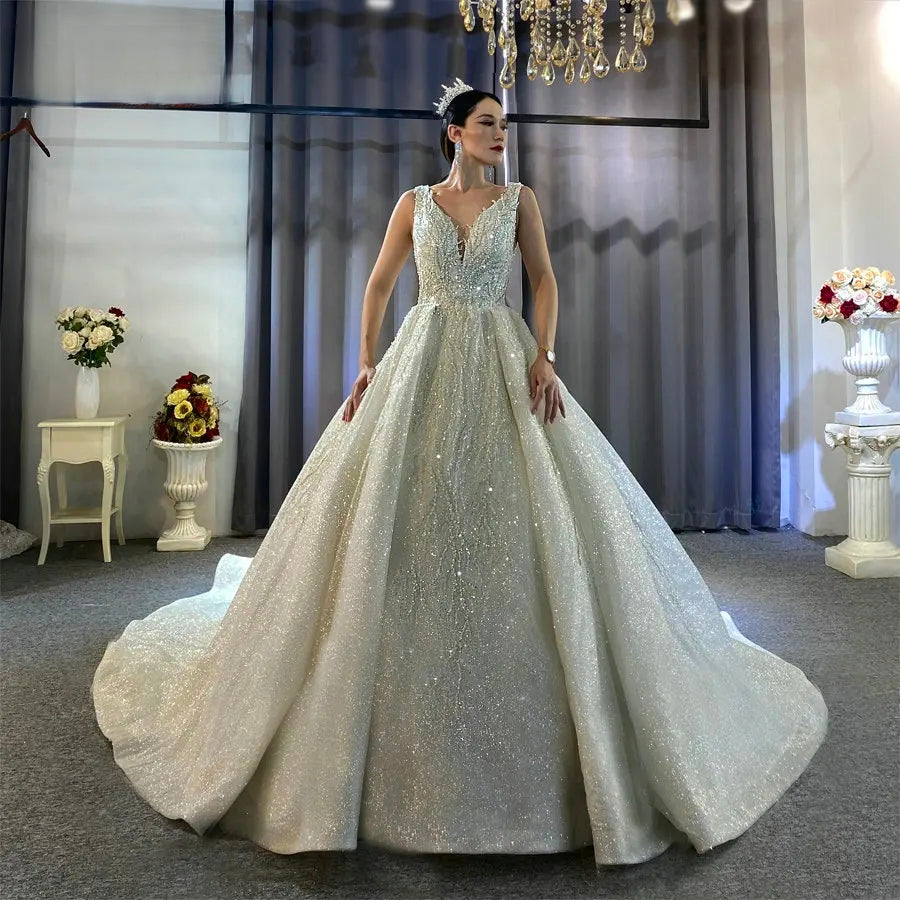 Full-length front view of a stunning sleeveless ball gown wedding dress featuring a deep V-neckline and a voluminous skirt crafted from shimmering, sparkly fabric.