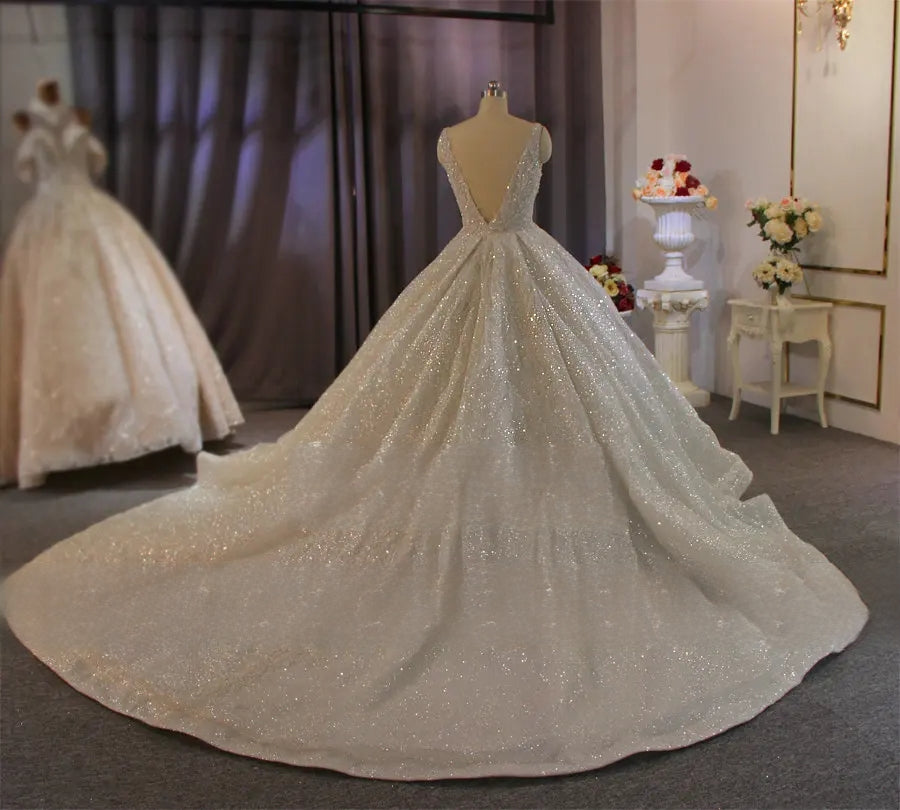 Rear perspective of the sleeveless wedding dress on a mannequin, featuring an elegant low V-back and a grand, shimmering cathedral-length train.