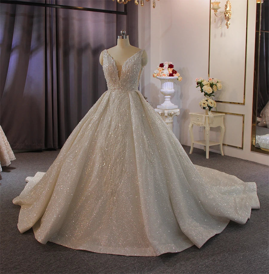Full front-side view of the luxury bridal gown, emphasizing the brilliant light-reflecting qualities of the shimmering fabric and the classic ball gown silhouette.
