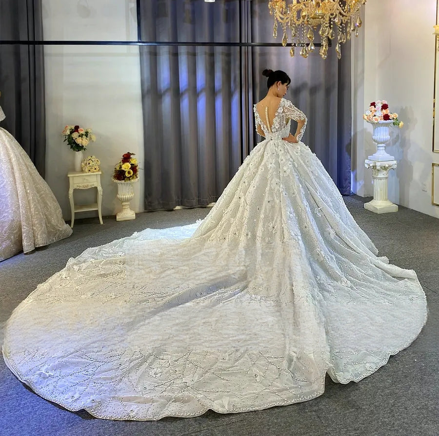 Rear view of the elegant wedding dress showcasing a deep V-back design and a magnificent cathedral-length train adorned with heavy crystal beading and 3D flowers.