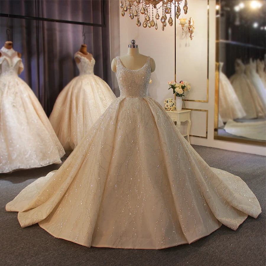 Mannequin display of a luxurious off-white sleeveless ball gown wedding dress, illustrating the elegant vine-like silver sequin patterns across the grand skirt.
