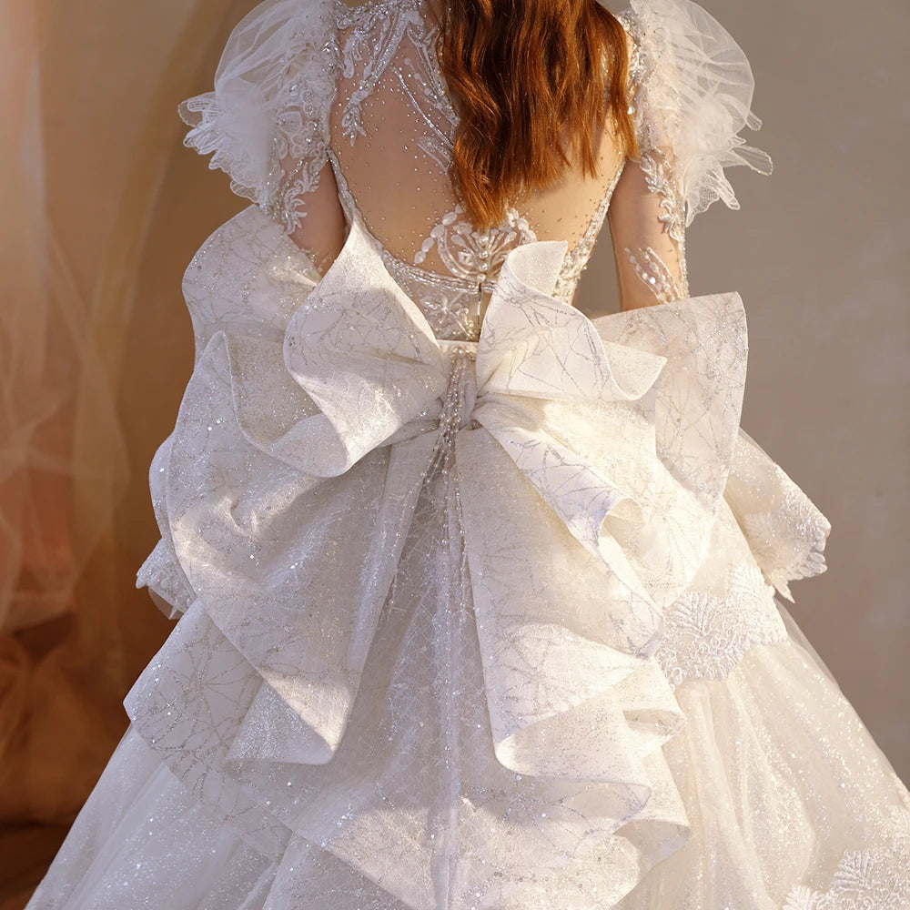Breathtaking full back view of the superfine wedding dress, showcasing the expansive, glittering cathedral-length train and the tiered bow accent beautifully spread on the floor.