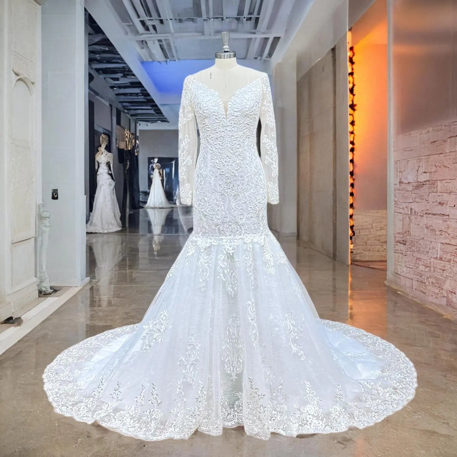 Front view of a white mermaid wedding dress with pearls and lace on a mannequin, showcasing the long sheer sleeves and fit-and-flare silhouette.