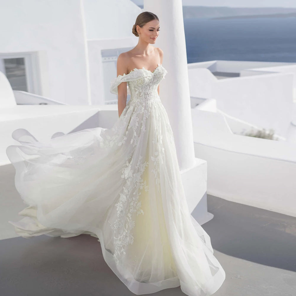 A bride posing on a white terrace overlooking the sea, wearing a sweetheart lace A-line vintage wedding dress with delicate floral appliques and a court train.