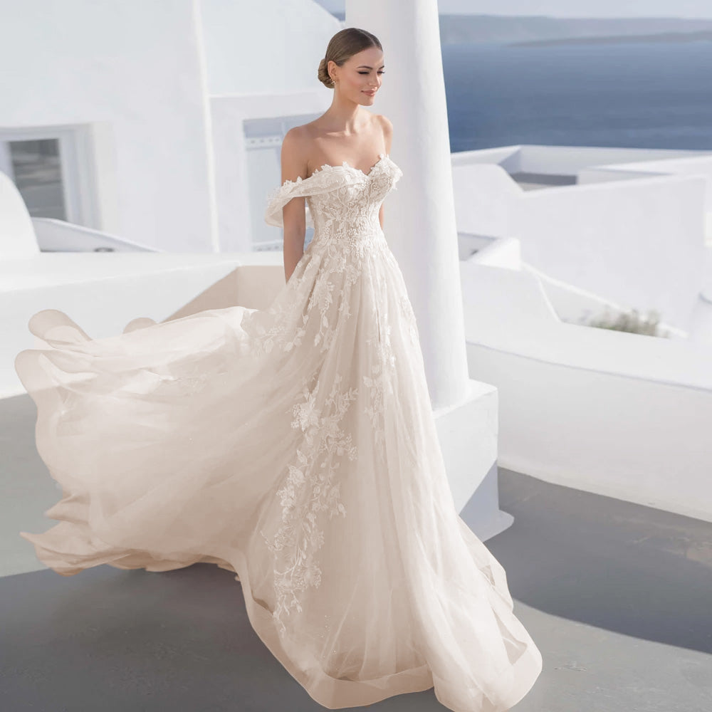 A beautiful bride standing on a sunlit white balcony, modeling a sweetheart lace A-line wedding dress with exquisite floral appliques and a court train.