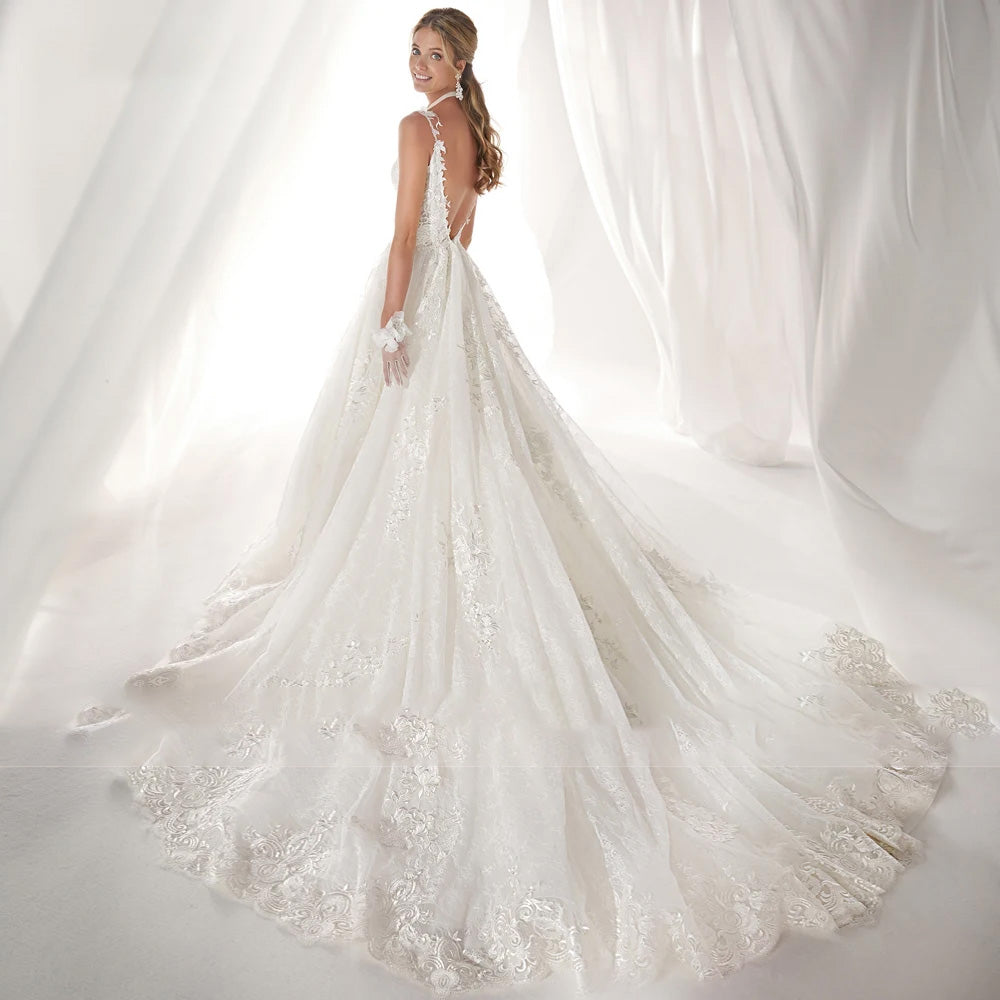 Back view of a sexy backless A-line wedding dress featuring delicate lace detailing and a flowing train.