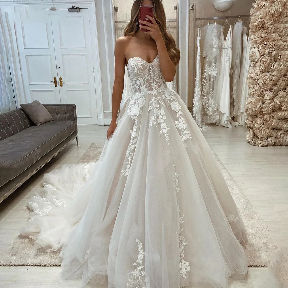 A side view of an elegant princess bridal gown featuring a sweetheart neckline, delicate lace appliqués, and a voluminous tulle skirt.
