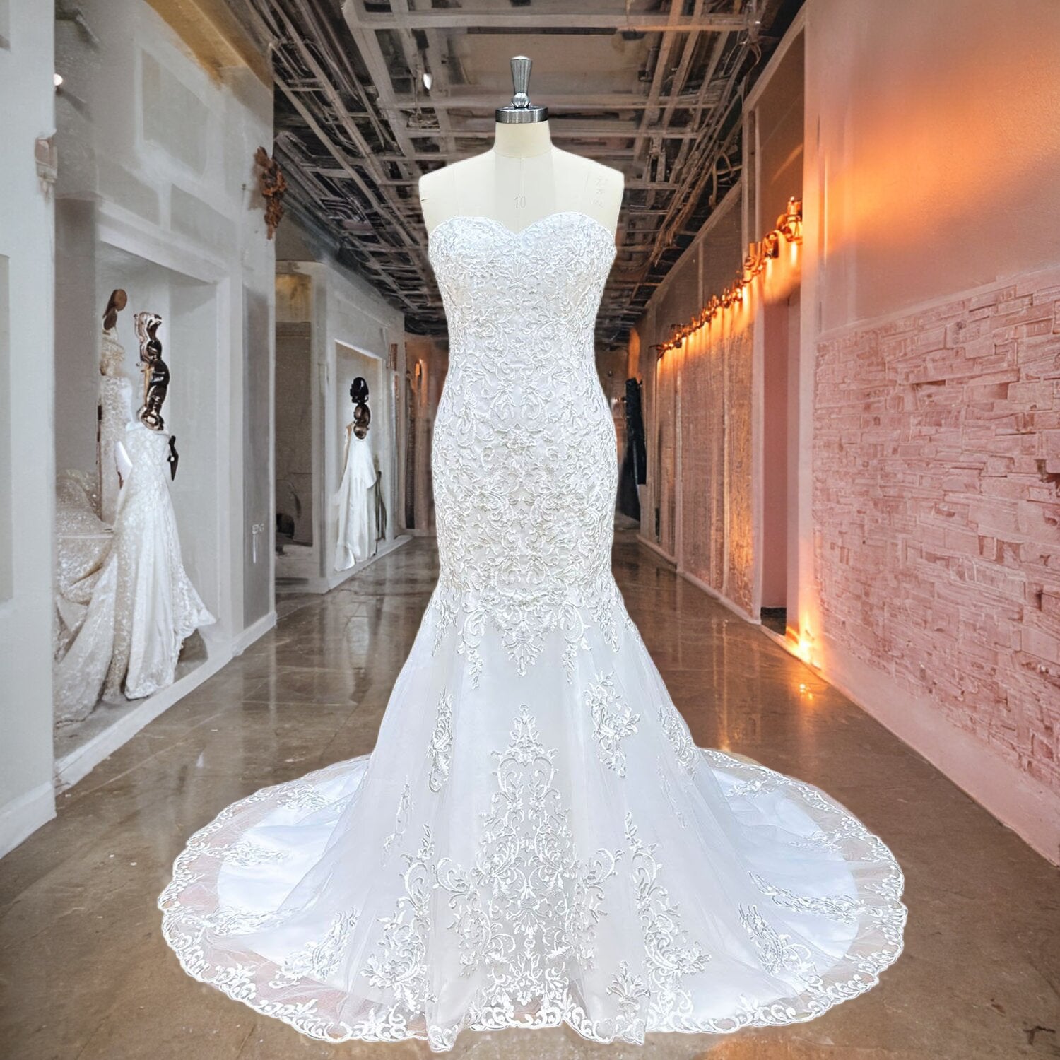 White sweetheart neckline mermaid wedding dress with elaborate lace overlays displayed on a mannequin in a bridal showroom hallway.
