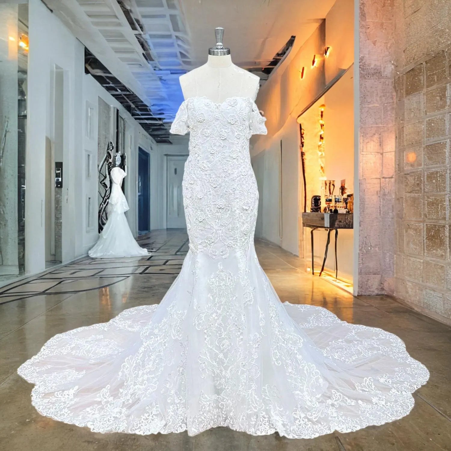 Mannequin display of an elegant white mermaid wedding dress with a deep sweetheart neckline, off-the-shoulder straps, and heavy pearl and floral appliques.