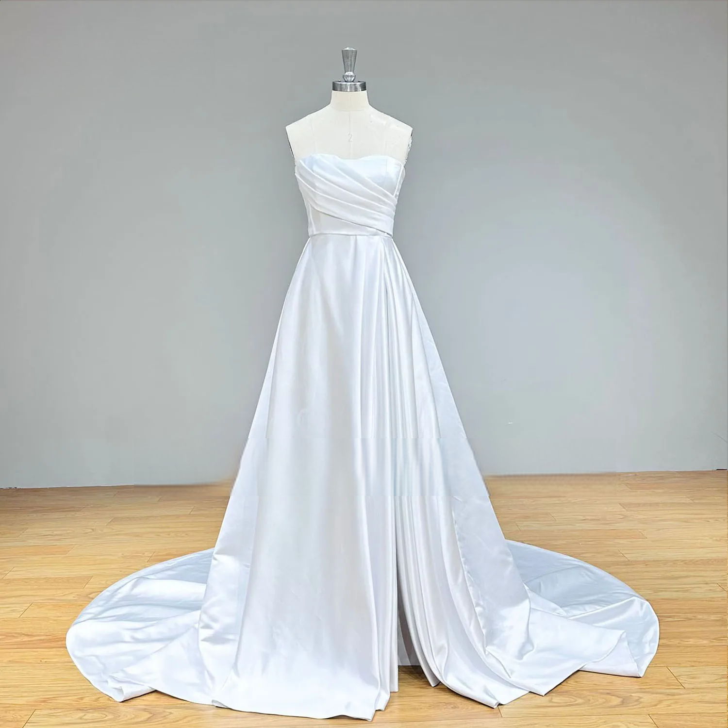 Full-length front perspective of a sweetheart neck satin A-line wedding dress on a mannequin, emphasizing the high skirt slit and classic silhouette.