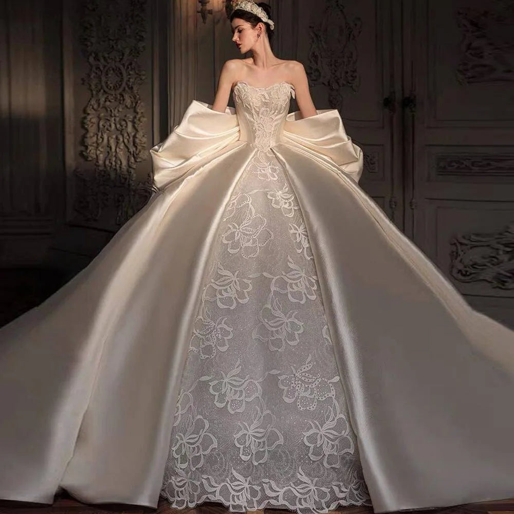 Front view of an elegant satin wedding dress with a sweetheart neckline and a dramatic back bow.