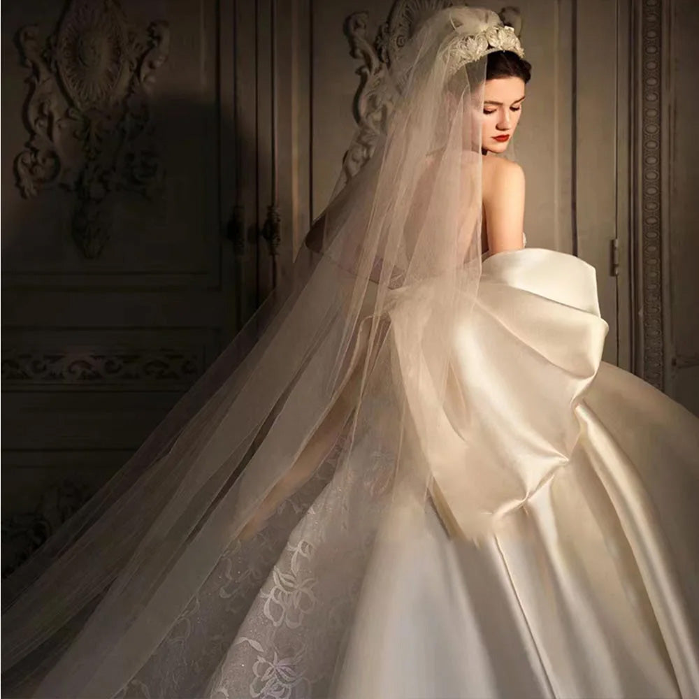 Side profile of an exquisite satin wedding dress showing the waist bow and sleek mermaid silhouette.