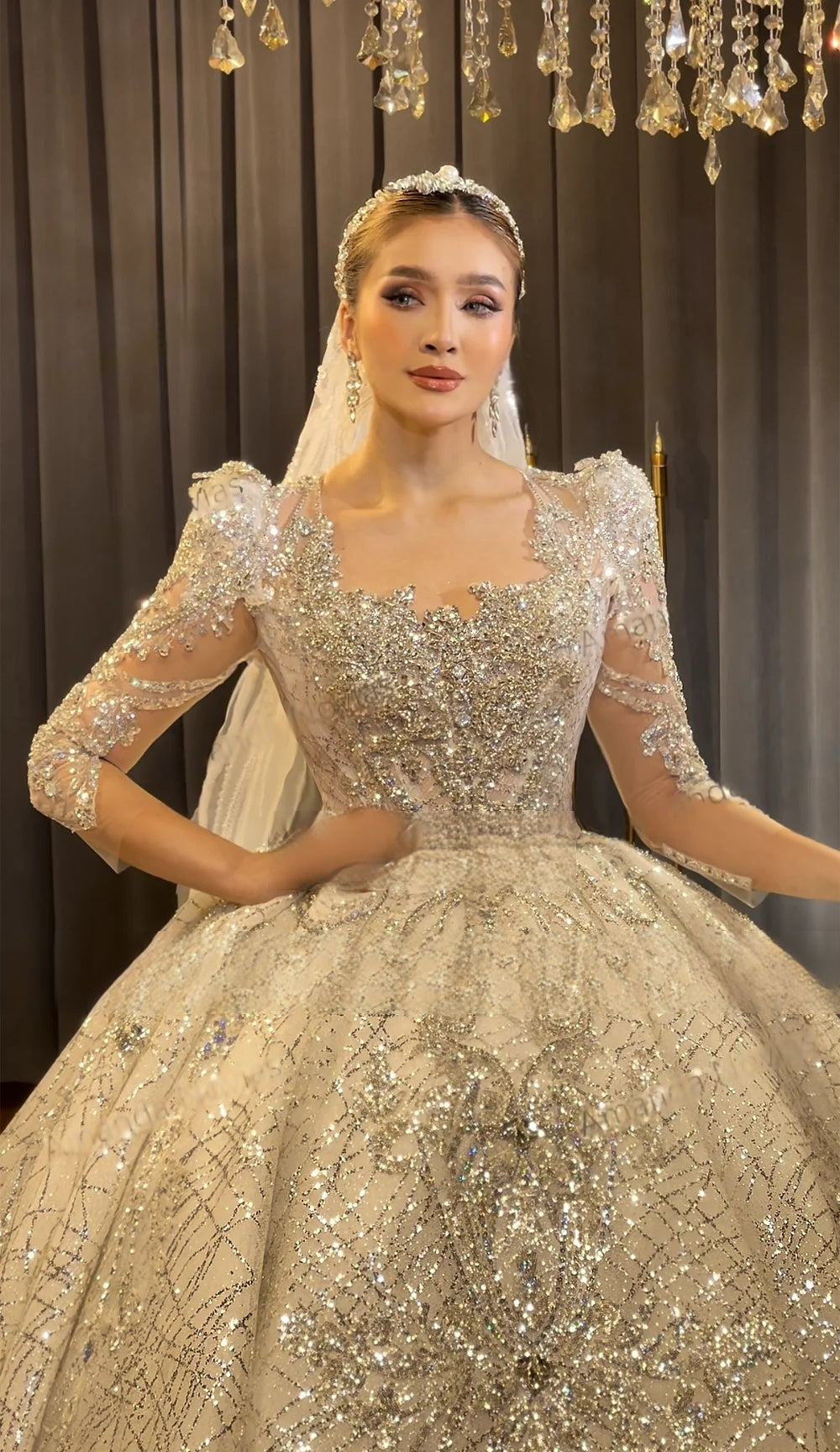 Close-up front view of a luxury sweetheart neckline wedding bodice with dense silver beading, structured long sleeves, and high-end 3D lace detailing.