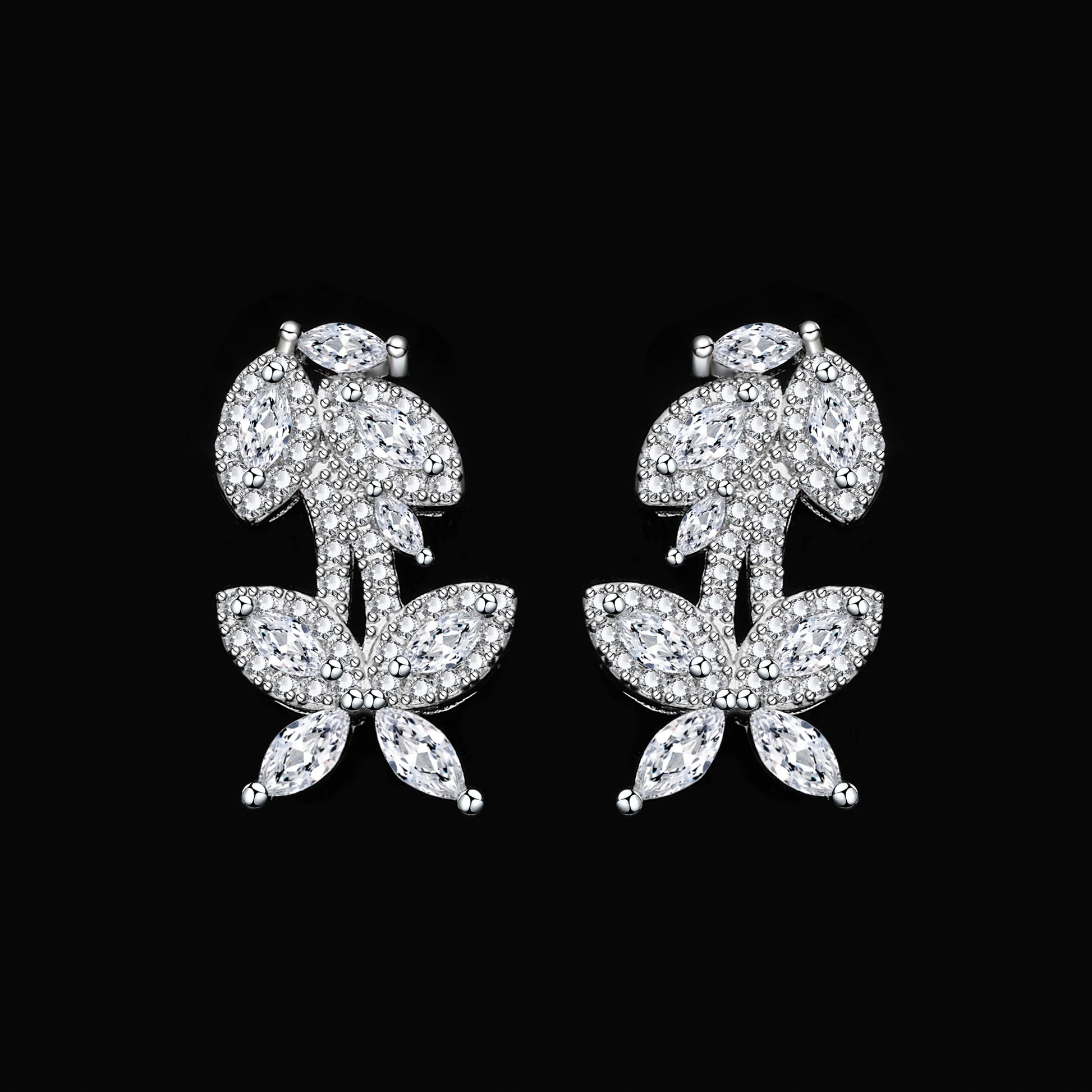 Close-up macro view of the matching cubic zirconia branch-design wedding earrings on a solid black background.