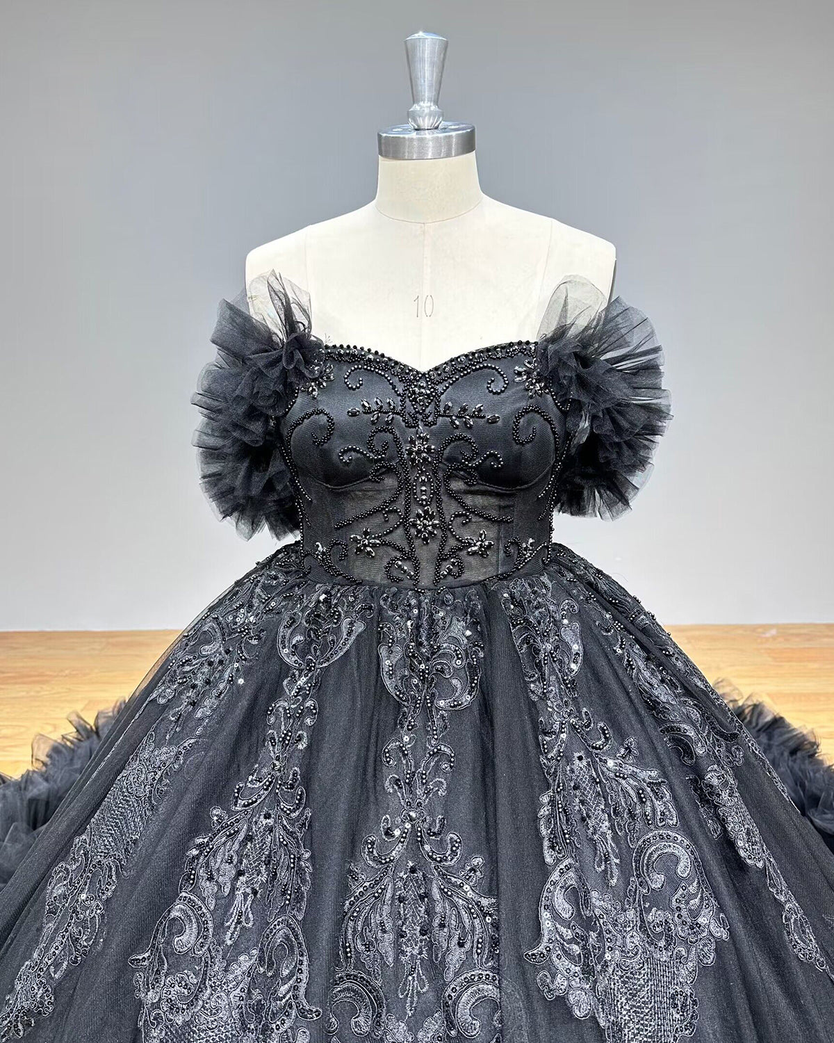 Detailed front close-up of a sweetheart bridal bodice showcasing intricate silver thread embroidery, floral lace appliques, and fine pearl bead clusters.